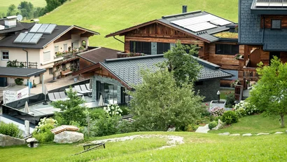 Bergdorf mit modernen und traditionellen Häusern auf grüner Wiese