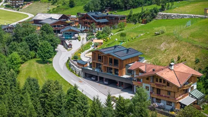 Bergdorf mit Holzhäusern und grünen Wiesen im Sommer
