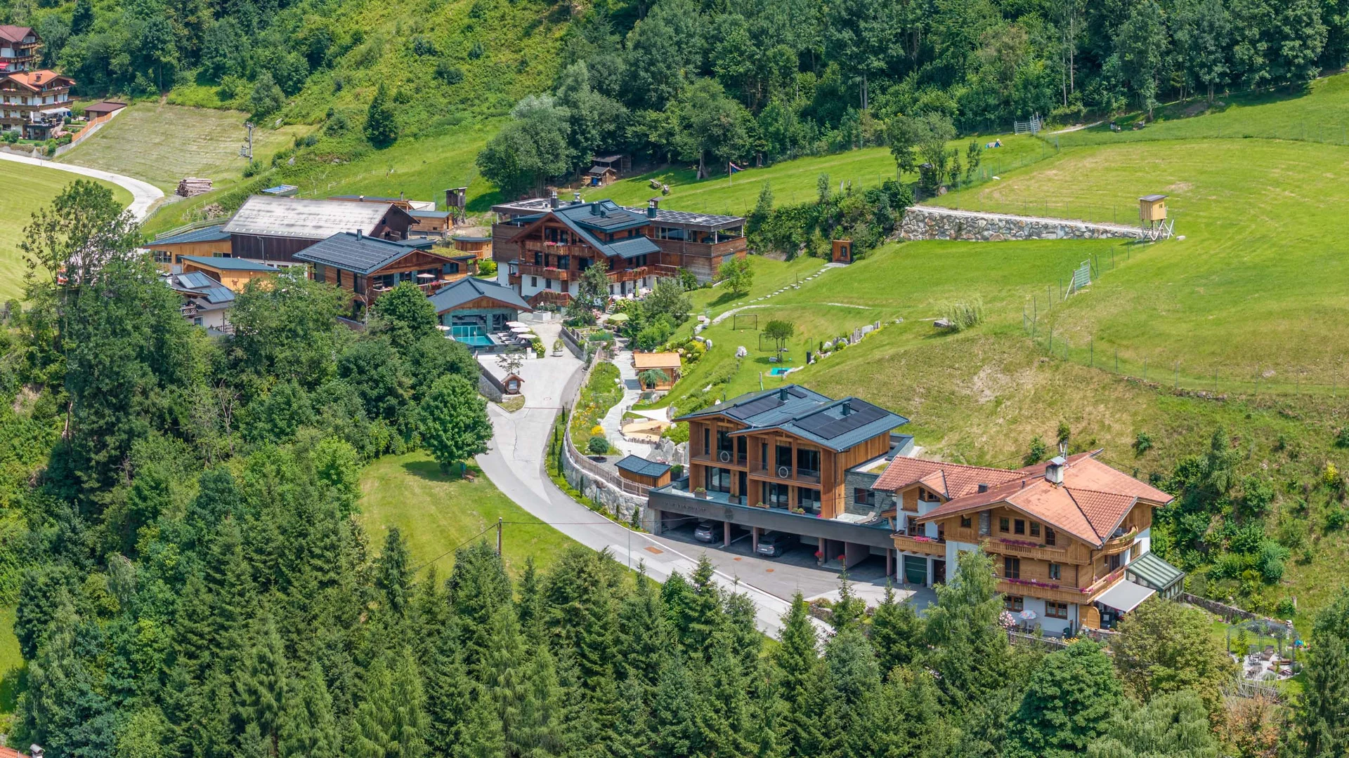 Bergdorf mit Häusern und viel Grün in einer idyllischen Landschaft